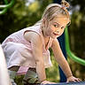 child, girl, toddler, portrait, smiling, crawling, outdoor, playground, pink_dress, hair_bow, blonde_hair, blue_eyes, face, hands, kneeling, sunlight, bokeh, greenery, photography, watermark