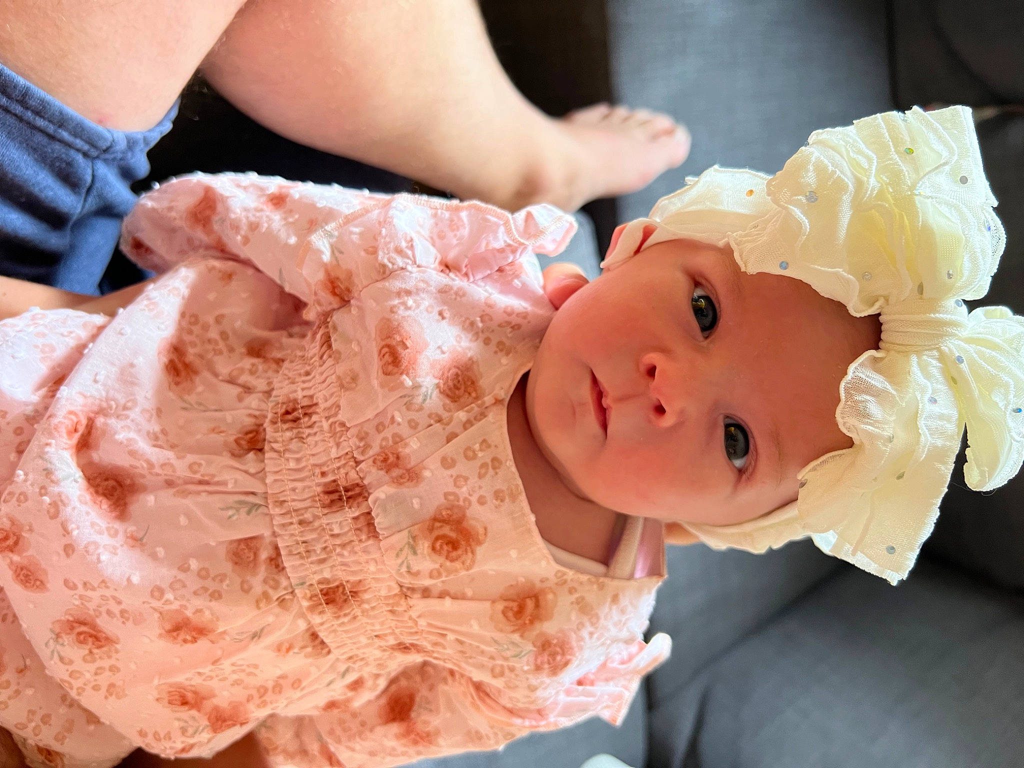 Amara is registered to the contest to win money with this photo: baby, child, dress, embellishment, eye, finger, gesture, hair, hand, happy, hat, head, headgear, headpiece, headwear, person, pink, plant, skin, smile