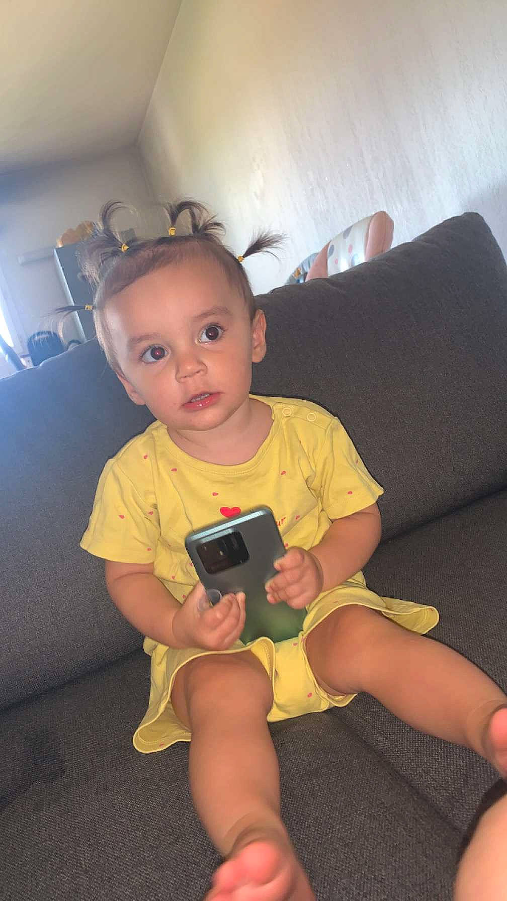 Maliya a rejoint le concours — aidez-le/la à gagner de superbes lots ! baby_toddler_clothing, child, comfort, couch, elbow, finger, foot, fun, gadget, human_leg, knee, lap, nail, person, room, sitting, sofa_bed, thigh, thumb, toddler