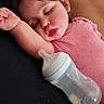 toddler, sleeping, baby_bottle, pink_clothing, arm_up, resting, indoor, cute, child, peaceful, face, hair, skin, person, young_child, relaxation, infant, laying_down, cozy, quiet