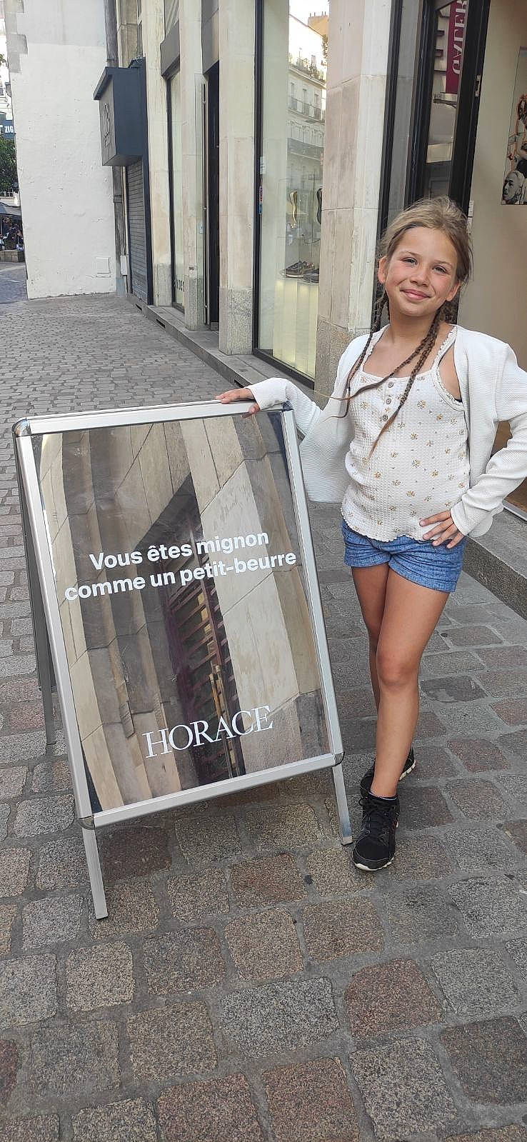 Louisa a rejoint le concours — aidez-le/la à gagner de superbes lots ! advertising, brown_hair, denim, electric_blue, eyewear, fashion_design, flooring, font, human_leg, joy, knee, long_hair, pedestrian, person, road, road_surface, sleeve, smile, street, thigh