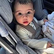 Elaina is registered to the contest to win money with this photo: baby, infant, car_seat, seatbelt, blanket, big_eyes, looking_up, portrait, child, cute, safety_harness, buttoned_shirt, plush, car_interior, cute_expression, face, head, hair, skin, hand