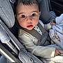 baby, infant, car_seat, seatbelt, blanket, big_eyes, looking_up, portrait, child, cute, safety_harness, buttoned_shirt, plush, car_interior, cute_expression, face, head, hair, skin, hand