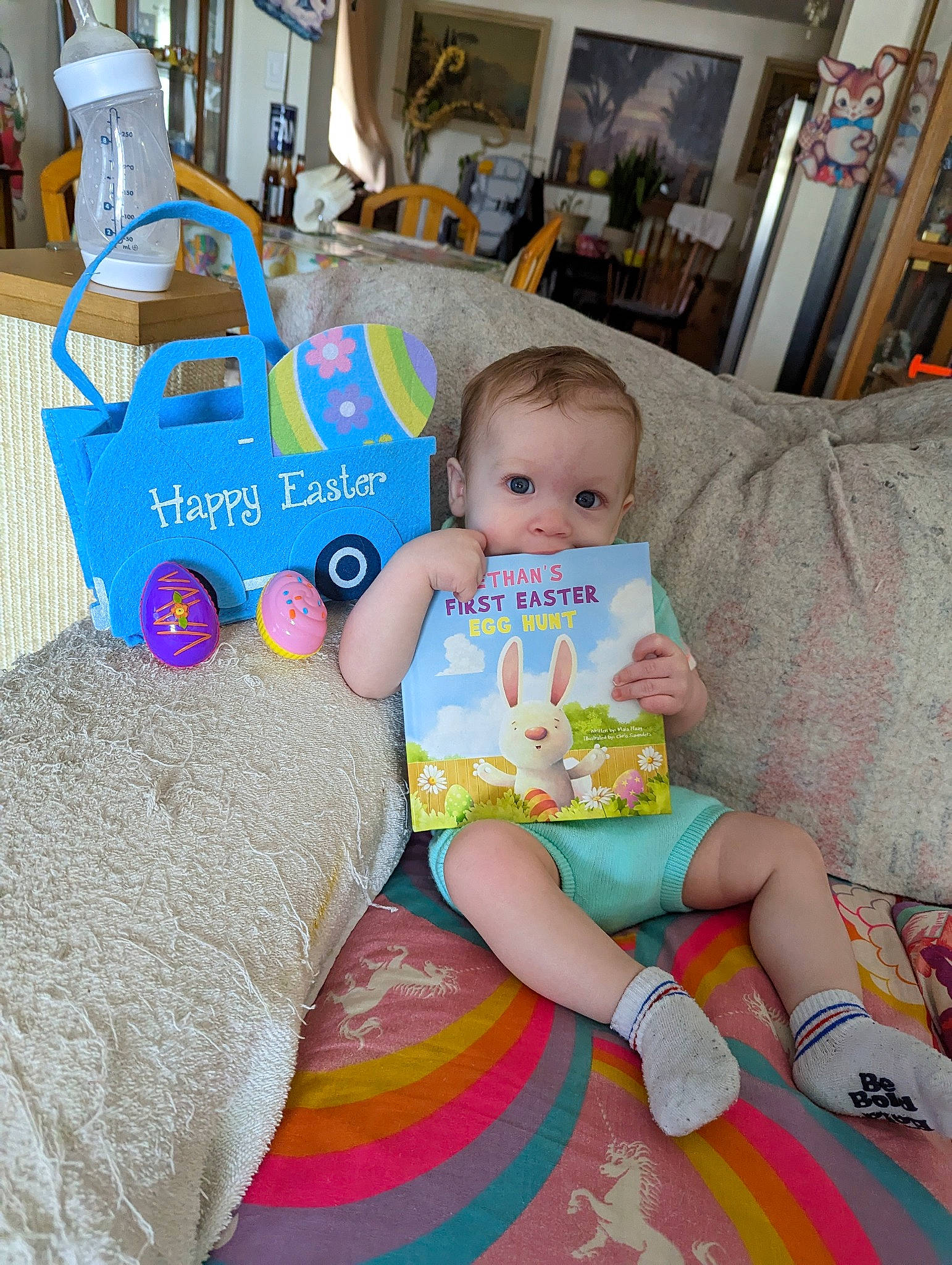 Ethan is registered to the contest to win money with this photo: baby, baby_products, baby_toddler_clothing, cheek, child, couch, flooring, fun, happy, lap, leisure, linens, person, picture_frame, play, room, sitting, t_shirt, textile, toddler