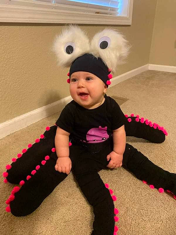 Rylee joined the competition — help win amazing prizes! baby, baby_toddler_clothing, cap, carmine, child, costume, costume_hat, flooring, fun, headwear, magenta, party_supply, person, pink, room, shoe, sitting, sleeve, smile, t_shirt