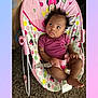 baby, infant, child, bouncy_seat, minnie_mouse, pink, polka_dot, onesie, indoor, carpet, buckle, curly_hair, bare_feet, looking_up, relaxed, seat_strap, patterned_fabric, toddler, portrait, baby_gear