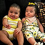 Nyrobi is registered to the contest to win money with this photo: baby, babies, child, smiling, sitting, couch, clothing, onesie, bow, pillow, pattern, happy, cute, indoor, person, infant, footwear, yellow, floral, portrait