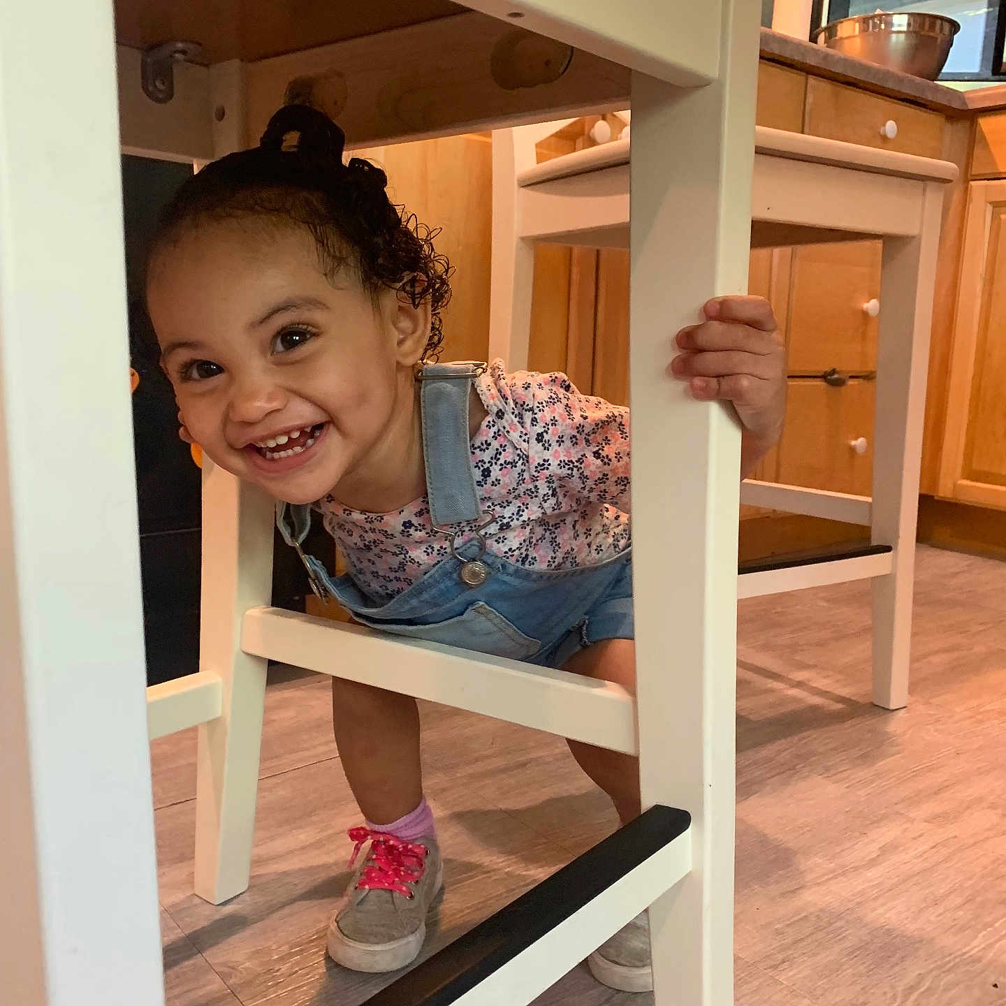 Malia joined the competition — help win amazing prizes! chair, child, clothing, face, female, footwear, furniture, girl, hardwood, head, hiding, highchair, person, shoe, sitting, takingcover, wood