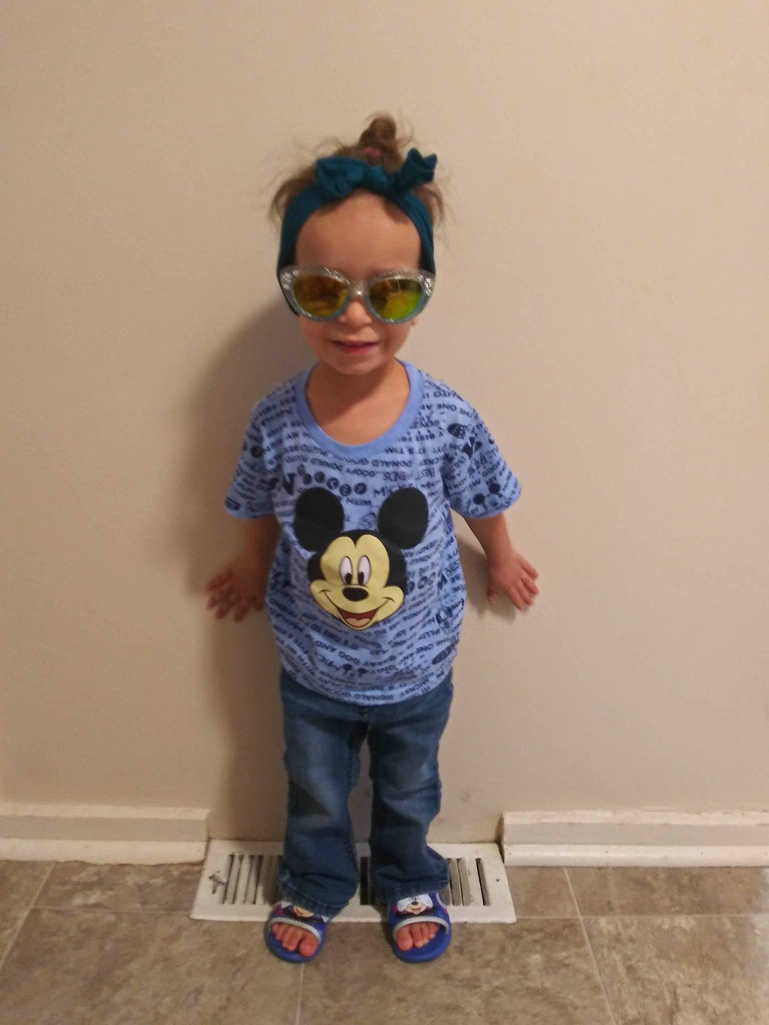 Aundrea is registered to the contest to win money with this photo: baby_toddler_clothing, child, clothing, electric_blue, eyewear, face, flooring, glasses, goggles, hair, happy, jeans, knee, neck, person, shoulder, sleeve, standing, t_shirt, toddler
