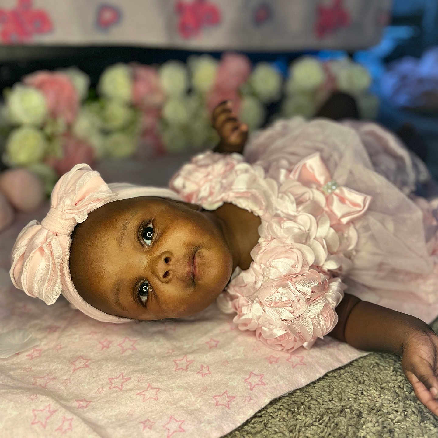 Maddison joined the competition — help win amazing prizes! baby, infant, pink_dress, headband, bow, blanket, soft_toy, flowers, carpet, lying_down, cute, portrait, child, face, indoors, closeup, adorable, peaceful, skin, hand