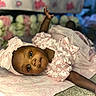 Maddison joined the competition — help win amazing prizes! baby, girl, infant, pink_dress, headband, bow, blanket, star_pattern, lying_down, cute, soft_texture, indoors, portrait, child, young, raising_hand, closeup, adorable, expression, clothing