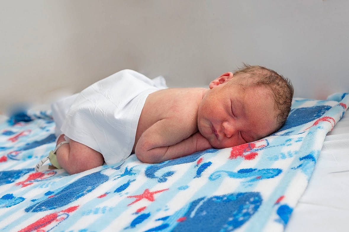 Brian is registered to the contest to win money with this photo: baby, baby_sleeping, bed_sheet, bedding, bedtime, blanket, child, comfort, event, grass, linens, nap, pattern, person, portrait_photography, room, sleep, textile, toddler, towel