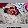 newborn, baby, infant, child, portrait, lying_down, pacifier, blanket, bed, bedding, striped_sheet, red_clothing, pink_clothing, sleeping_area, indoor, home, face, hands, baby_photo, text_overlay