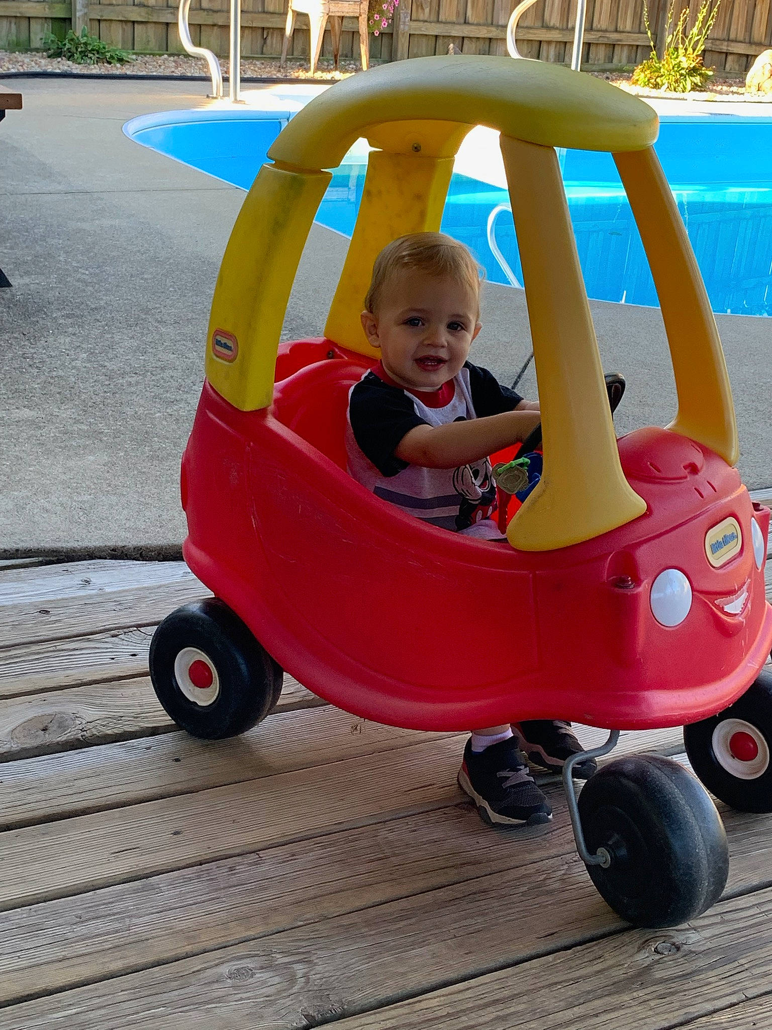 Anthony is registered to the contest to win money with this photo: automotive_wheel_system, baby, baby_carriage, baby_products, baby_toddler_clothing, child, fun, leisure, magenta, motor_vehicle, person, play, public_space, recreation, riding_toy, smile, tire, toddler, travel, vehicle