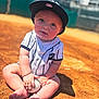 Caleb joined the competition — help win amazing prizes! baby, child, baseball, sports_uniform, cap, outdoor, field, dirt, sunlight, sitting, cute, portrait, hands, feet, person, infant, summer, play, ball, young