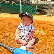 Caleb joined the competition — help win amazing prizes! baby, baseball, baseball_bat, baseball_field, baseball_cap, child, sports_equipment, toy, sunny, outdoor, sand, sport, cute, sitting, grass, fence, stadium, playful, daytime, young_child