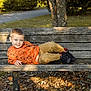 Braxton joined the competition — help win amazing prizes! child, boy, smile, bench, outdoor, park, autumn, leaves, grass, tree, clothing, orange_sweater, pants, shoes, happy, casual, daylight, nature, playful, portrait