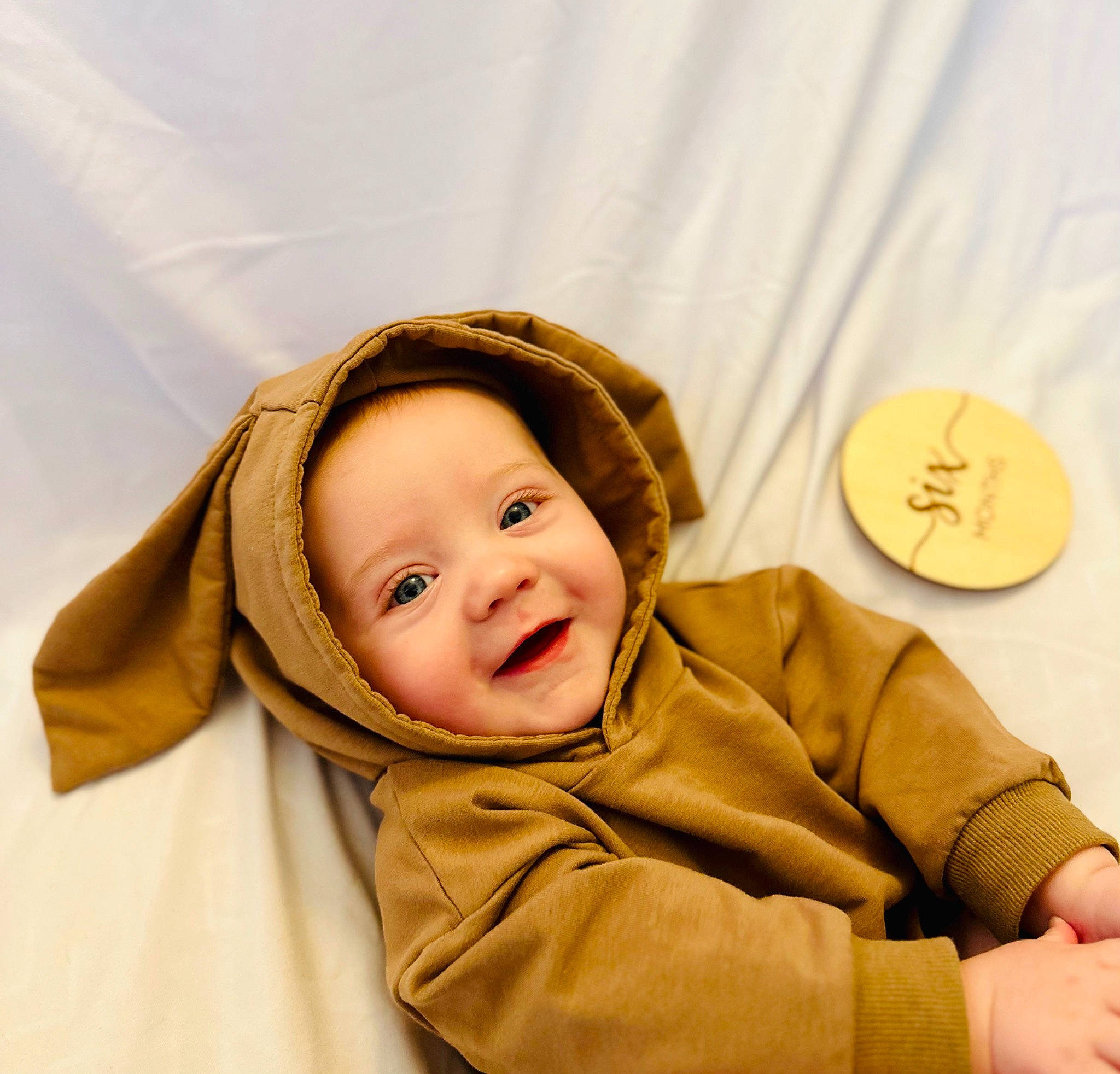 Quill is registered to the contest to win money with this photo: baby, baby_laughing, baby_toddler_clothing, cheek, child, comfort, eye, fun, gesture, happy, joy, laugh, linens, person, portrait_photography, room, sitting, skin, sleeve, smile