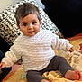 baby, child, infant, sweater, knitted_clothing, leggings, bed, blanket, pillow, indoor, portrait, cute, smiling, sitting, foot, face, person, cozy, warm, soft