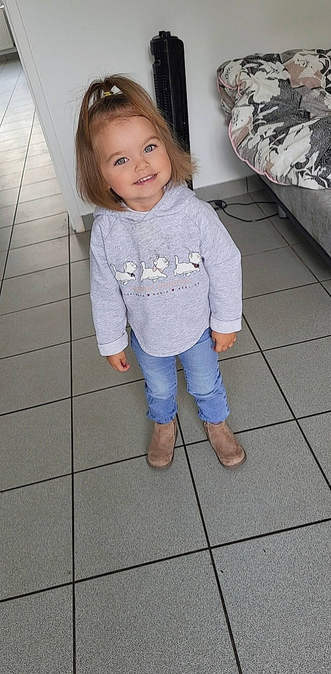 Mia participe au concours pour gagner de l'argent avec cette photo : baby_toddler_clothing, child, denim, eye, floor, flooring, hair, happy, head, joint, joy, knee, leg, person, shoulder, skin, sleeve, smile, t_shirt, textile
