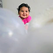 Sandra I Quintanilla joined the competition — help win amazing prizes! baby, child, smile, pink_clothing, curly_hair, portrait, indoor, happy, face, cute, infant, young_child, expression, human, person, background, soft_focus, blurry_foreground, joy, head