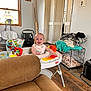 Henry is registered to the contest to win money with this photo: activity_center, baby, baby_equipment, baby_toys, blanket, car_seat, child, clothing, couch, dog_crate, flooring, furniture, household_items, indoor, light, person, room, smiling, window, wood_floor