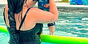 Henry joined the competition — help win amazing prizes! adult, baby, braid, child, dinosaur_print, fun, greenery, hat, holding, outdoor, parent, playful, pool_noodle, recreation, smile, summer, sunny, swimming_pool, swimsuit, water