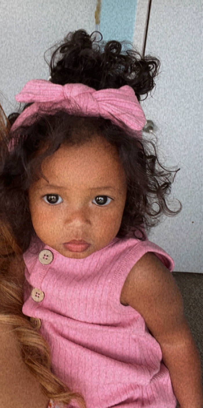 Adelyn is registered to the contest to win money with this photo: baby_toddler_clothing, black_hair, cheek, chin, ear, eyebrow, eyelash, face, forehead, happy, headgear, iris, lip, magenta, nose, organ, person, pink, purple, skin