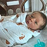 Branden is registered to the contest to win money with this photo: newborn, baby, infant, wrapped, blanket, elephant_pattern, hospital, bassinet, pacifier, curious, lying_down, indoors, face, person, cute, small, sleeping_area, soft, white, orange