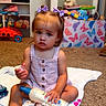 toddler, child, girl, hair_bows, lotion_bottle, carpet, towel, toy_box, butterfly_print, toys, shelves, shoes, indoor, room, clothing, sitting, expression, floor, pink, white