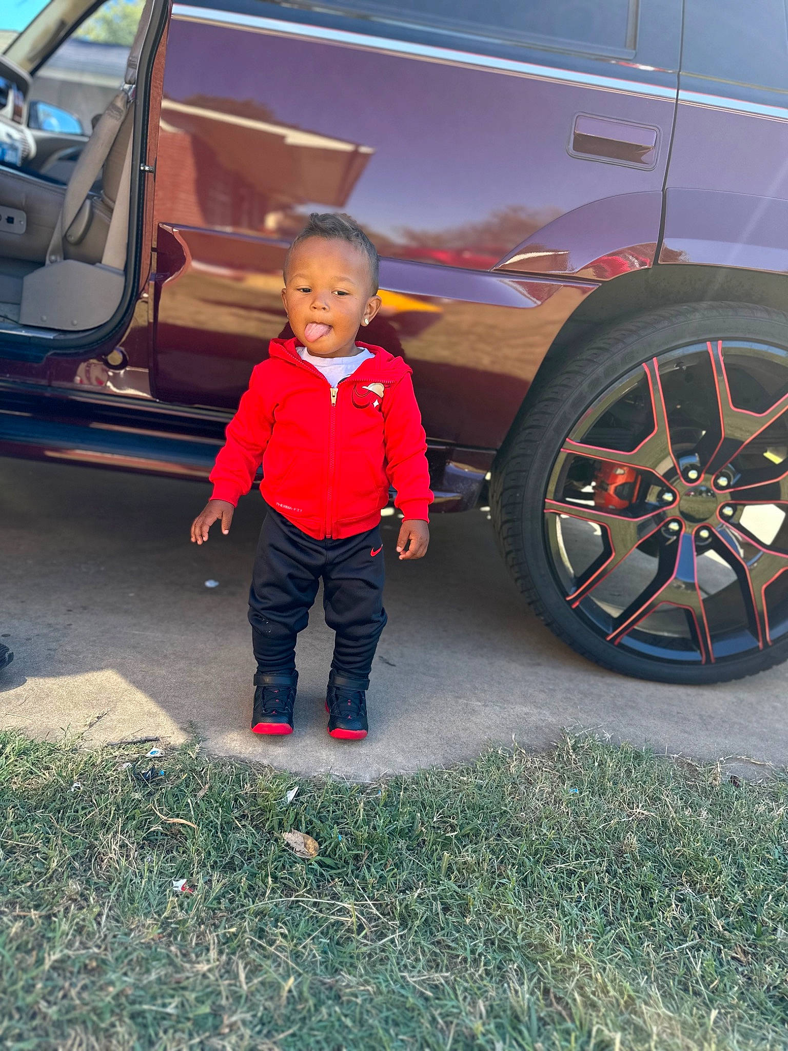 Deonte is registered to the contest to win money with this photo: alloy_wheel, automotive_design, automotive_exterior, automotive_lighting, automotive_tire, automotive_wheel_system, car, fender, hood, jacket, land_vehicle, motor_vehicle, person, plant, rolling, tire, toddler, tread, vehicle, vehicle_door