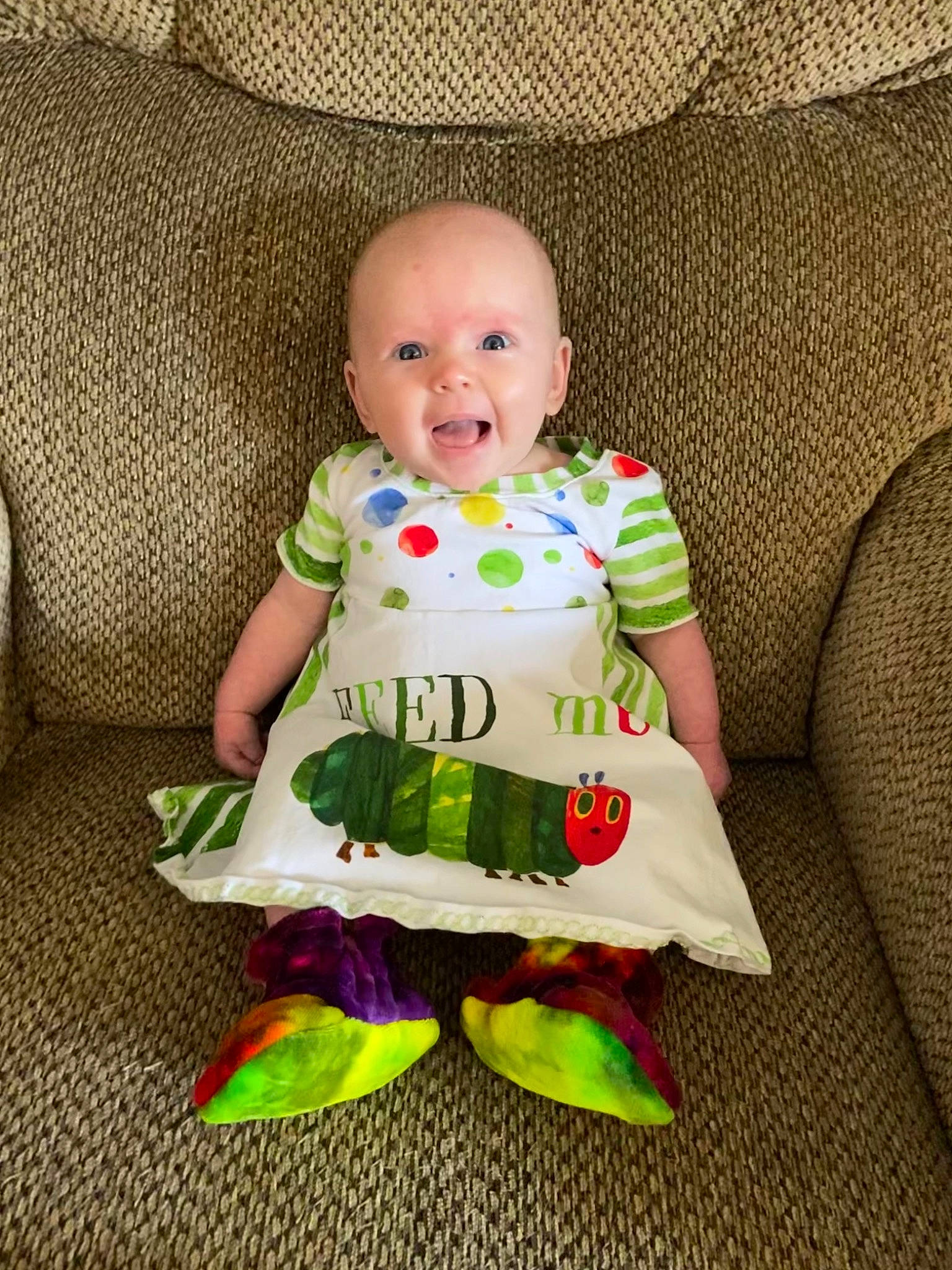 Mayleigh is registered to the contest to win money with this photo: baby, baby_products, baby_toddler_clothing, cheek, child, comfort, couch, dress, eye, face, happy, head, iris, linens, person, purple, sleeve, smile, t_shirt, textile