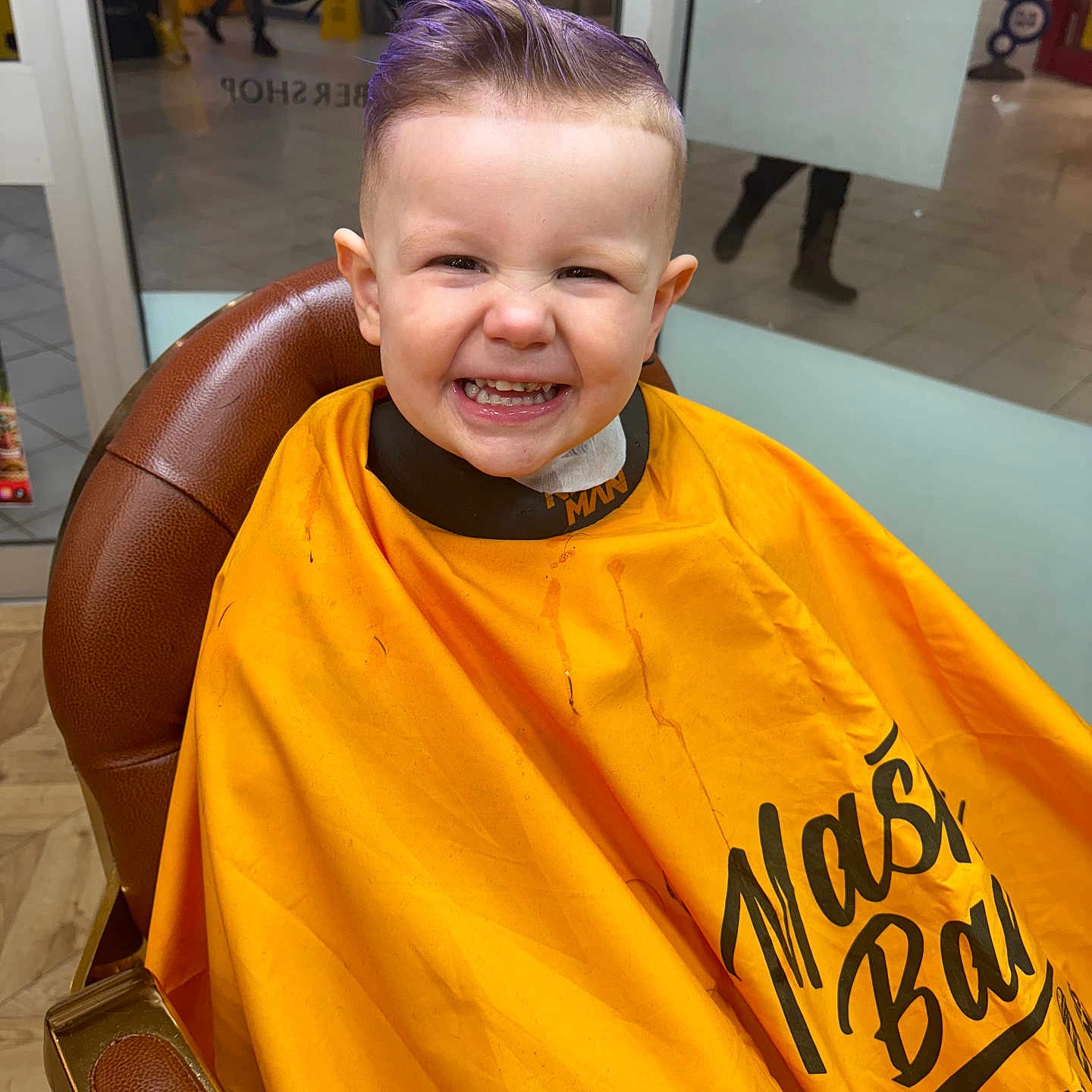 Theo is registered to the contest to win money with this photo: barber, barbershop, chair, child, cute, floor, haircut, haircut_cape, hairstyle, happy, indoor, kid, person, portrait, purple_hair, reflection, seat, smile, toddler, yellow_cape