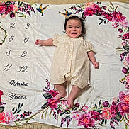 Sobhya is registered to the contest to win money with this photo: baby, infant, child, smiling, portrait, lying_down, milestone_blanket, floral, flowers, hummingbird, cream_dress, bow, indoor, blanket, textile, photography, happy, face, family_photo, milestone