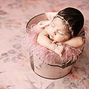 Eliana is registered to the contest to win money with this photo: newborn, baby, sleeping, pink, fluffy, bucket, headband, flower, soft, portrait, cute, infant, peaceful, resting, skin, arms, closeup, indoors, decor, gentle