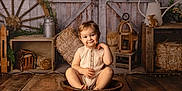 Loïs participe au concours pour gagner de l'argent avec cette photo : toddler, child, smile, wooden_bowl, wooden_floor, rustic, vintage, wagon_wheel, hay_bale, watering_can, lantern, wooden_crate, plant, indoor, portrait, cute, sitting, cozy, farm_style, decor