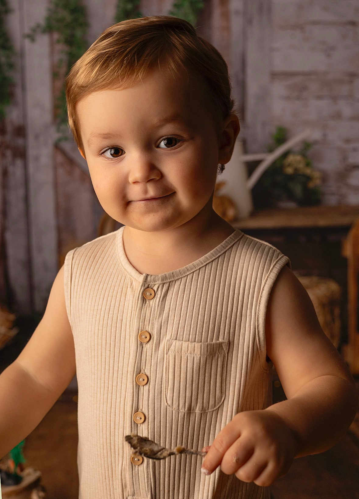 Loïs a rejoint le concours — aidez-le/la à gagner de superbes lots ! toddler, child, smile, face, spoon, beige_clothing, buttoned_shirt, short_hair, indoor, warm_lighting, portrait, person, cute, happy, rustic_background, wooden_furniture, decor, cozy, young_child, closeup