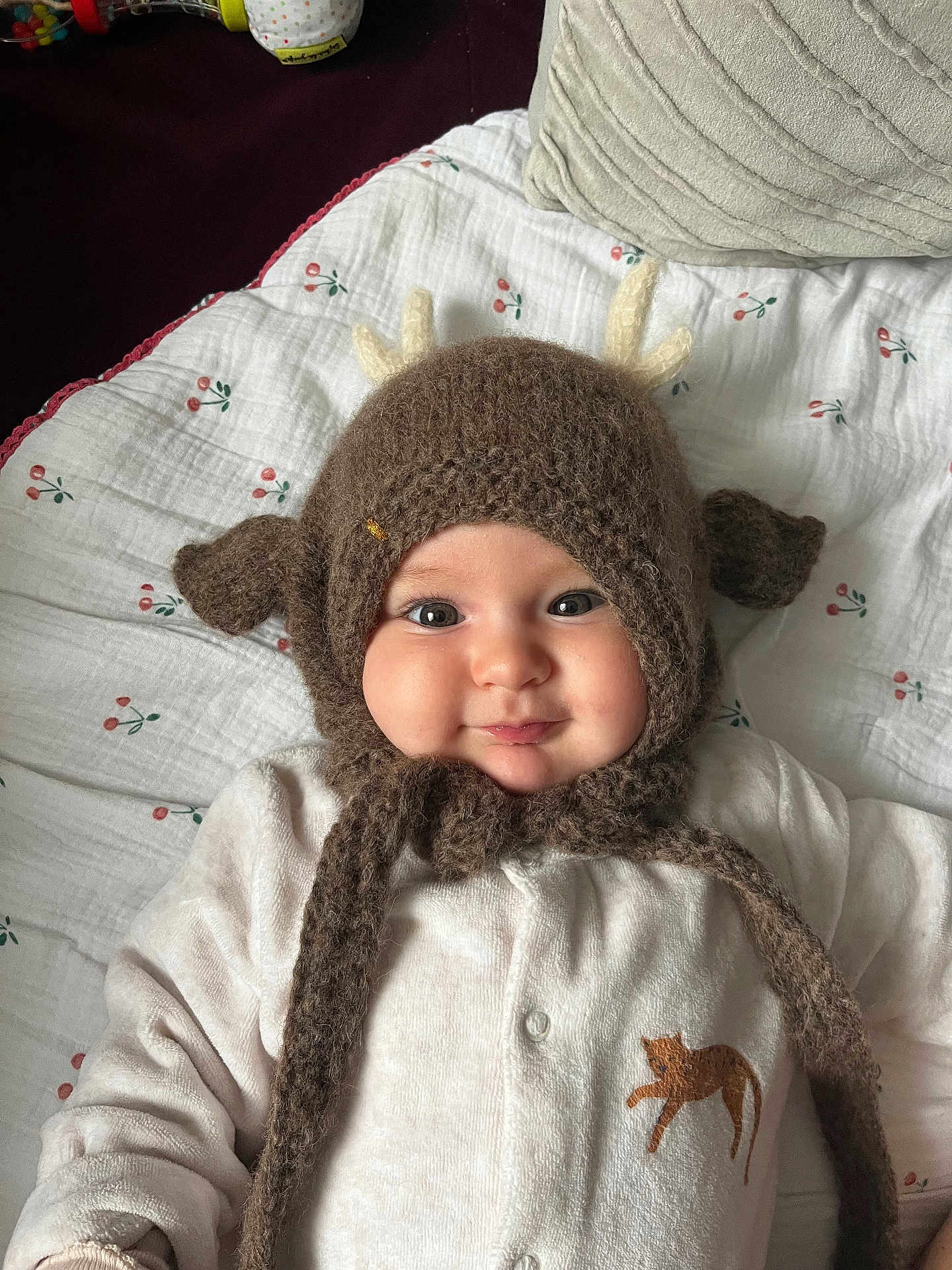 Marguerite a rejoint le concours — aidez-le/la à gagner de superbes lots ! baby, infant, smile, cheeks, knitted_hat, antlers, blanket, onesie, cat_patch, pillow, toy, indoor, portrait, close_up, cute, eyes, face, soft_texture, cozy, baby_clothing