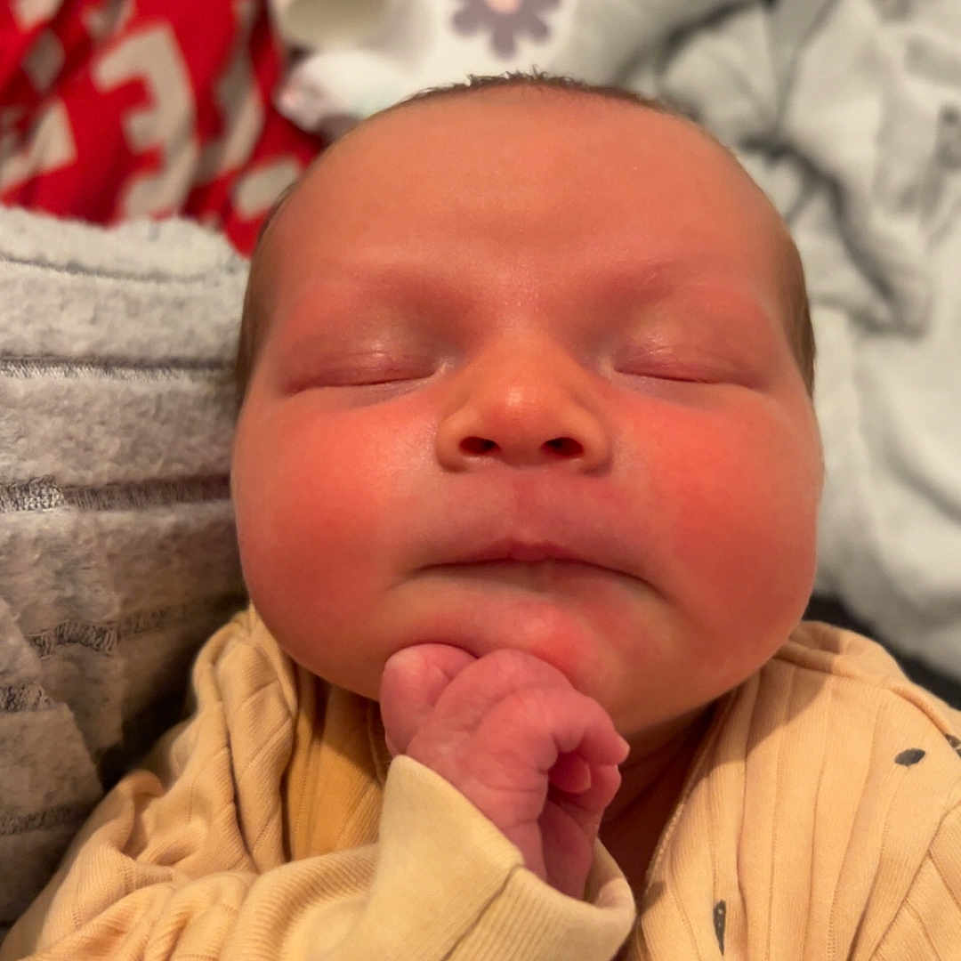 Mayleigh joined the competition — help win amazing prizes! baby, blanket, bodypart, clothing, face, finger, glove, hand, hat, head, hoodie, knitwear, mouth, newborn, person, photography, portrait, quilt, sleeping, sweater