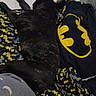 animal, batman, bedding, bedroom, black_and_yellow, black_dog, blanket, cozy, dog, indoors, lying_down, nap, pet, pillow, plush_toy, portrait, relaxed, sleeping, superhero, tile_floor