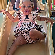 Kimora joined the competition — help win amazing prizes! baby, child, slide, playground, smiling, happy, dress, bow, braids, sandals, outdoor, person, fun, cute, joy, summer, park, ramp, leisure, activity