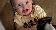 Atlas joined the competition — help win amazing prizes! baby, child, couch, smile, blue_eyes, sock, clothing, toddler, furniture, indoor, happy, person, cute, sitting, playful, blond_hair, infant, holding, foot, relaxed