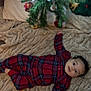 baby, blanket, child, christmas_tree, cozy, cute, decorations, face, festive, green, holiday, indoor, infant, ornaments, pajamas, person, plaid, red, smiling, soft_texture