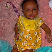 Kacey is registered to the contest to win money with this photo: accessories, baby, blanket, clothing, couch, cushion, dress, face, furniture, happy, head, homedecor, indoors, person, photography, portrait, quilt, sitting, smile, toy