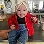 baby, child, smiling, headwrap, red_jacket, jeans, socks, indoor, kitchen, counter, person, happy, cute, portrait, clothing, hand, support, infant, young_child, casual