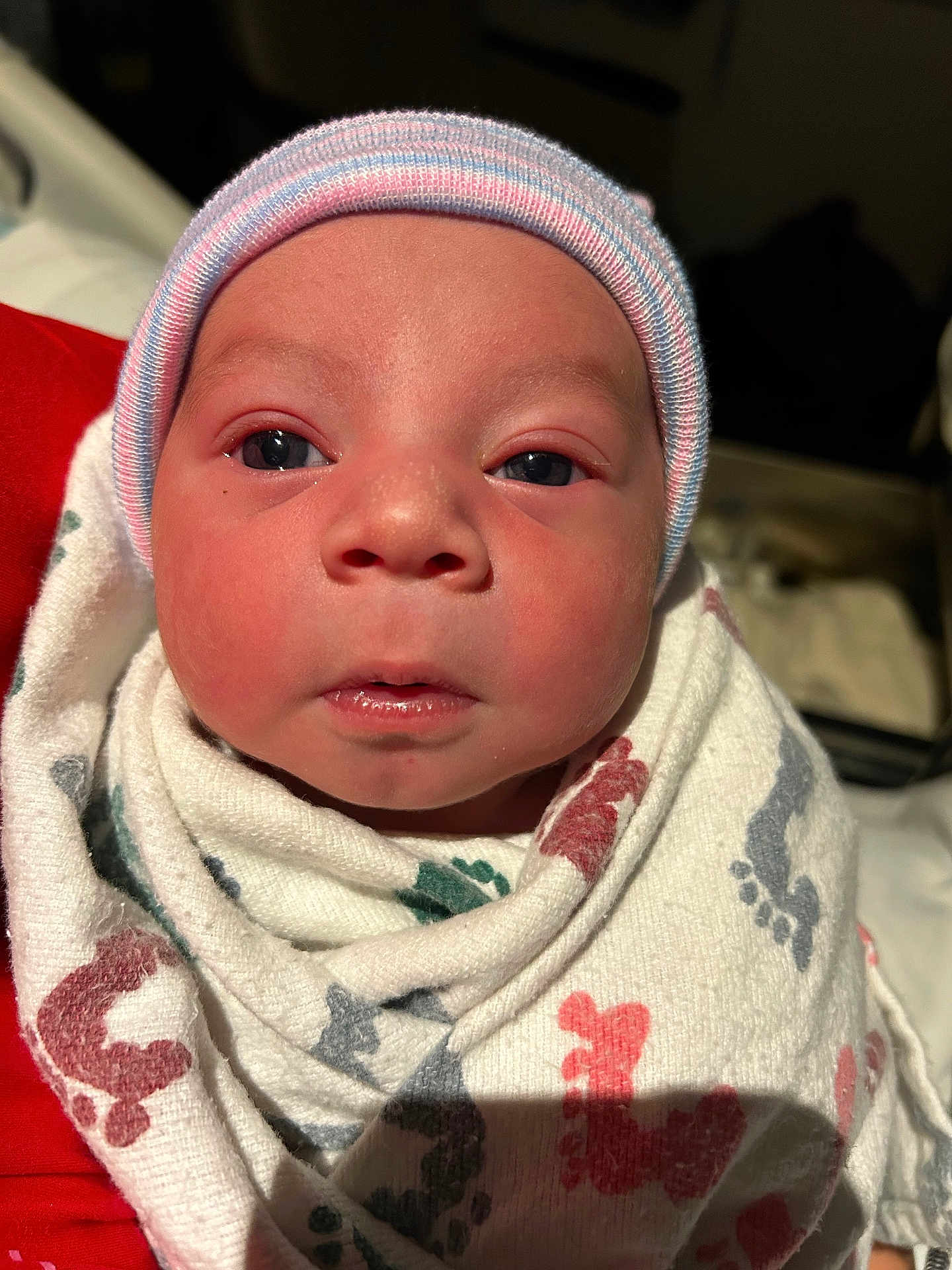 Littlejoe is registered to the contest to win money with this photo: newborn, baby, infant, swaddle, hospital_blanket, striped_cap, cap, face, eyes, nose, mouth, close_up, portrait, indoor, hospital, blanket, footprint_pattern, skin, cozy, adorable