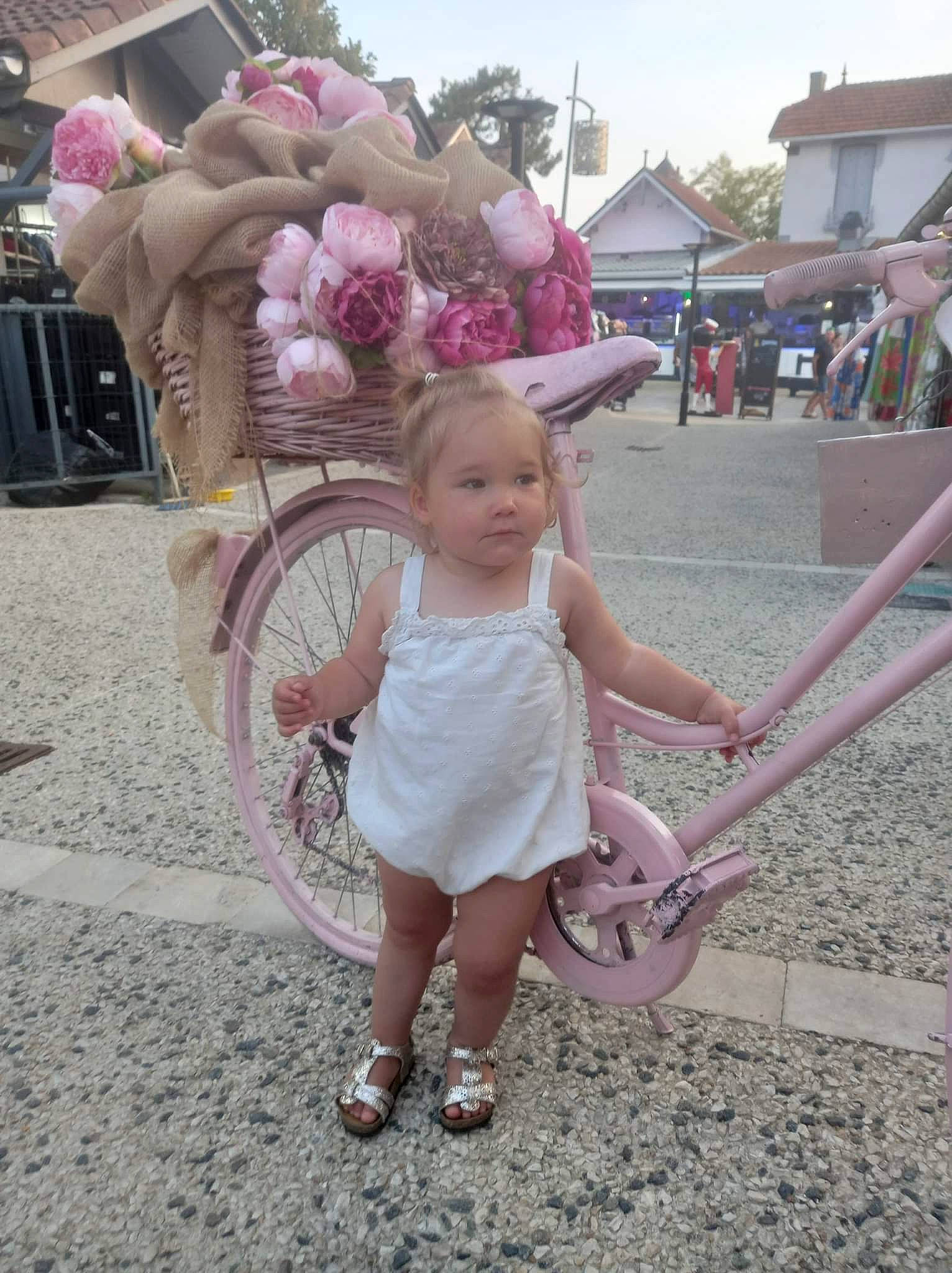 Iris a rejoint le concours — aidez-le/la à gagner de superbes lots ! baby_toddler_clothing, bicycle_tire, dress, flower, fun, hairstyle, happy, human_body, leg, leisure, magenta, person, pink, recreation, sandal, shoe, sky, sneakers, tire, toddler