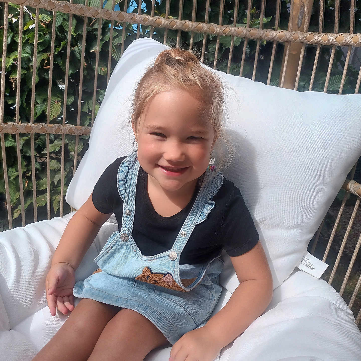 Iris participe au concours pour gagner de l'argent avec cette photo : bodypart, child, clothing, cushion, face, female, finger, furniture, girl, hand, happy, head, homedecor, jeans, pants, person, photography, portrait, sitting, smile