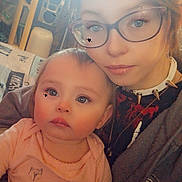 Aradia is registered to the contest to win money with this photo: baby, child, woman, glasses, indoor, portrait, casual, clothing, spiked_collar, holding, face, person, young, seated, home, furniture, soft_lighting, expression, closeup, family