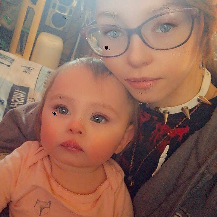 Aradia is registered to the contest to win money with this photo: baby, child, woman, glasses, indoor, portrait, casual, clothing, spiked_collar, holding, face, person, young, seated, home, furniture, soft_lighting, expression, closeup, family